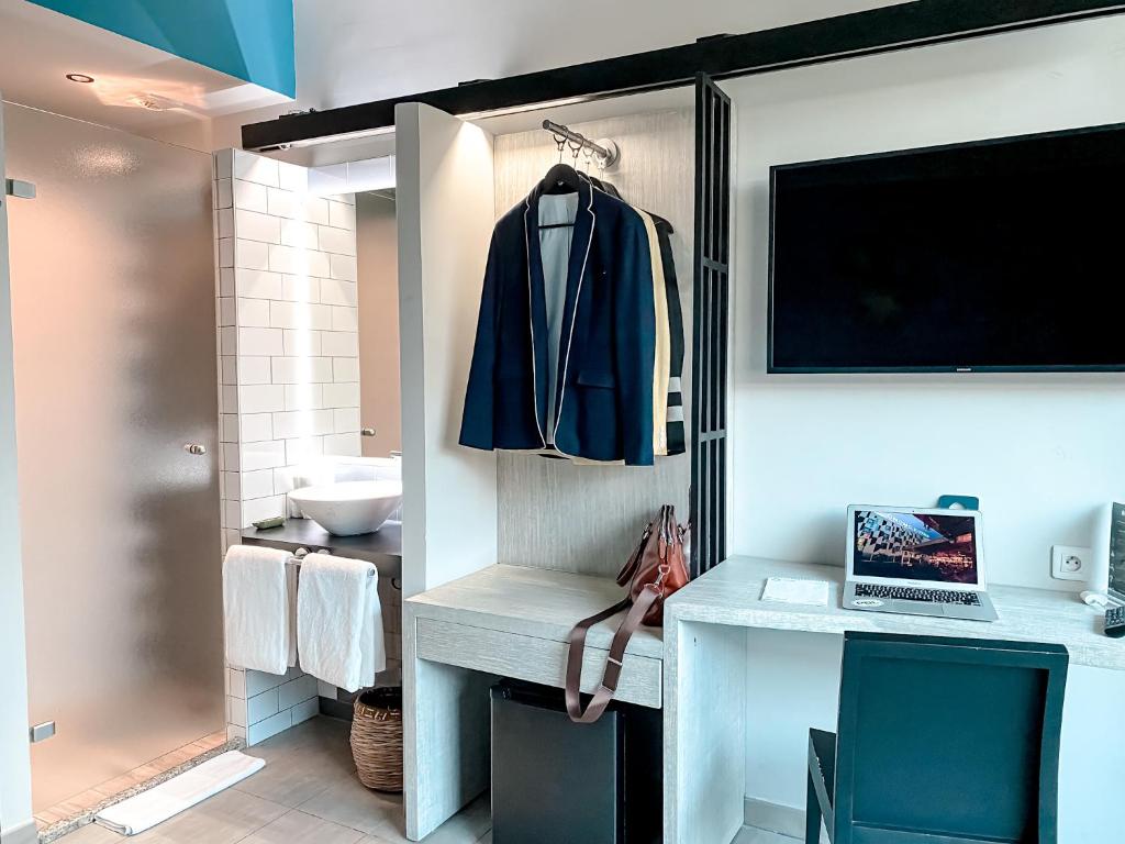 a bathroom with a desk with a laptop on it at ONOMO Hotel Abidjan in Abidjan