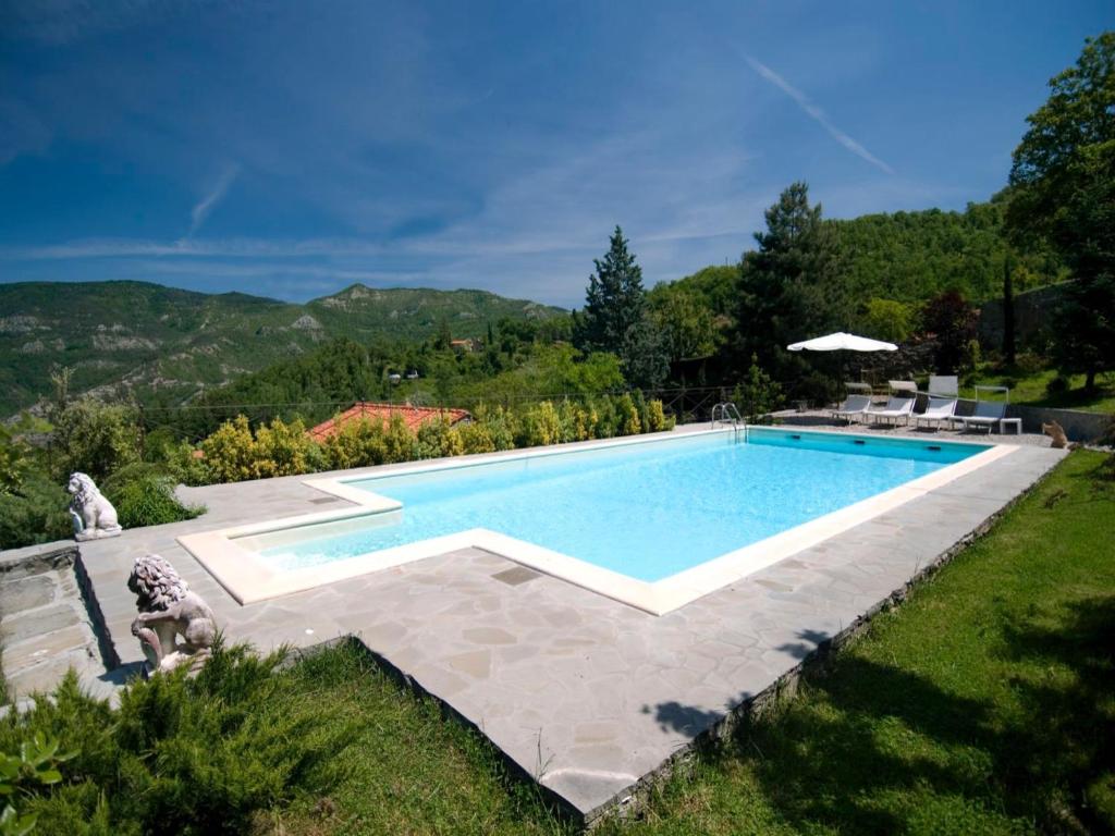 a swimming pool in a yard with a mountain in the background at Villa La Fonte 13 in San Godenzo