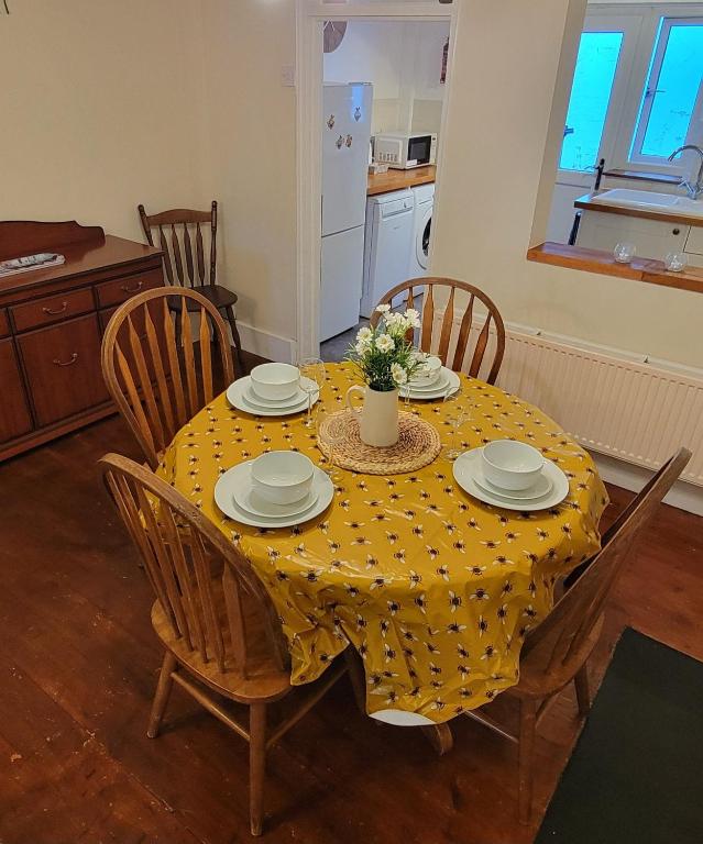 a dining room table with a yellow polka dot table cloth at Bee Cottage in Sandown