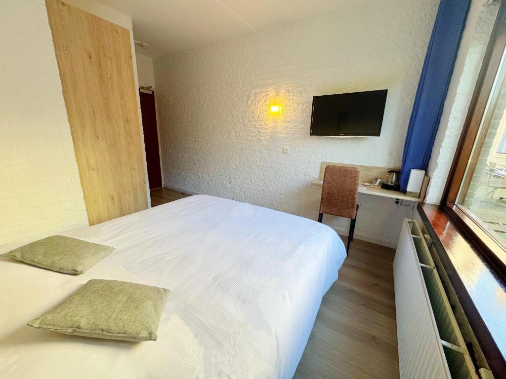 Postel nebo postele na pokoji v ubytování Hotel Dordrecht