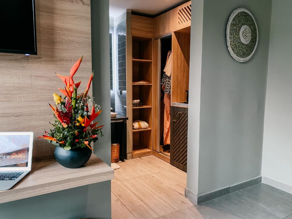a hallway with a vase of flowers on a counter at ONOMO Hotel Abidjan in Abidjan