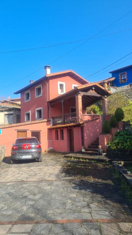 a house with a car parked in front of it at Casa la fuente in Vibaño