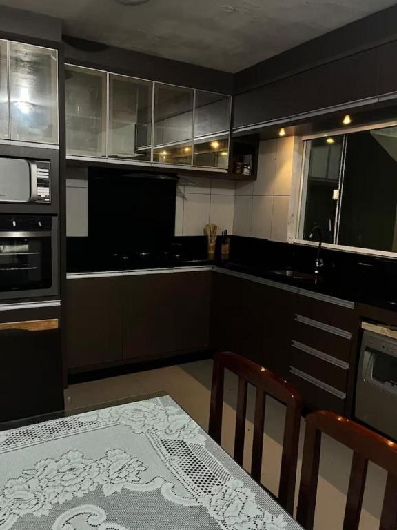 a kitchen with a table and a stove and a microwave at Luciene in Xangri-lá