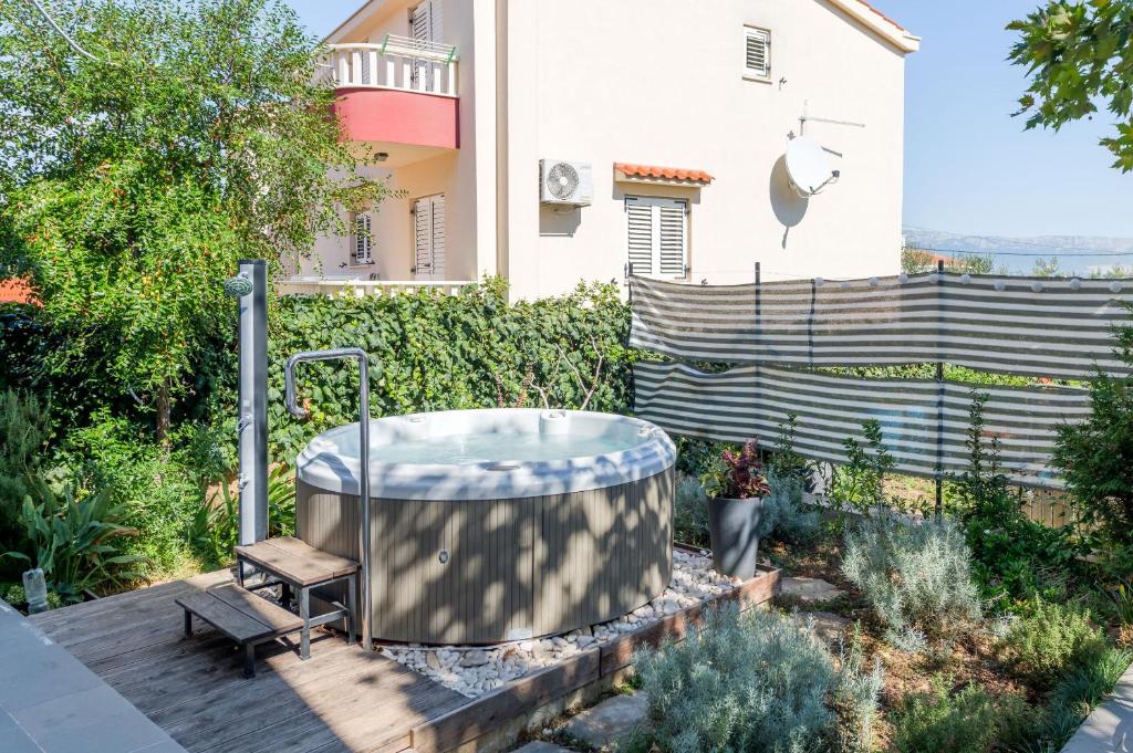 a hot tub in a garden next to a house at Apartments Deepwater in Slatine
