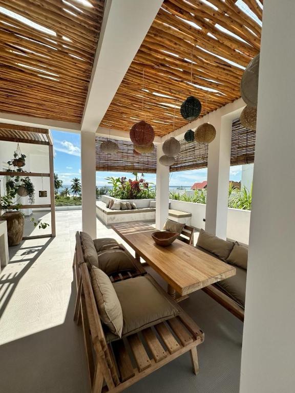 a living room with a wooden table and a couch at Bahari View, Stylish Penthouse with breathtaking oceanviews and private rooftop pool in Kiwengwa