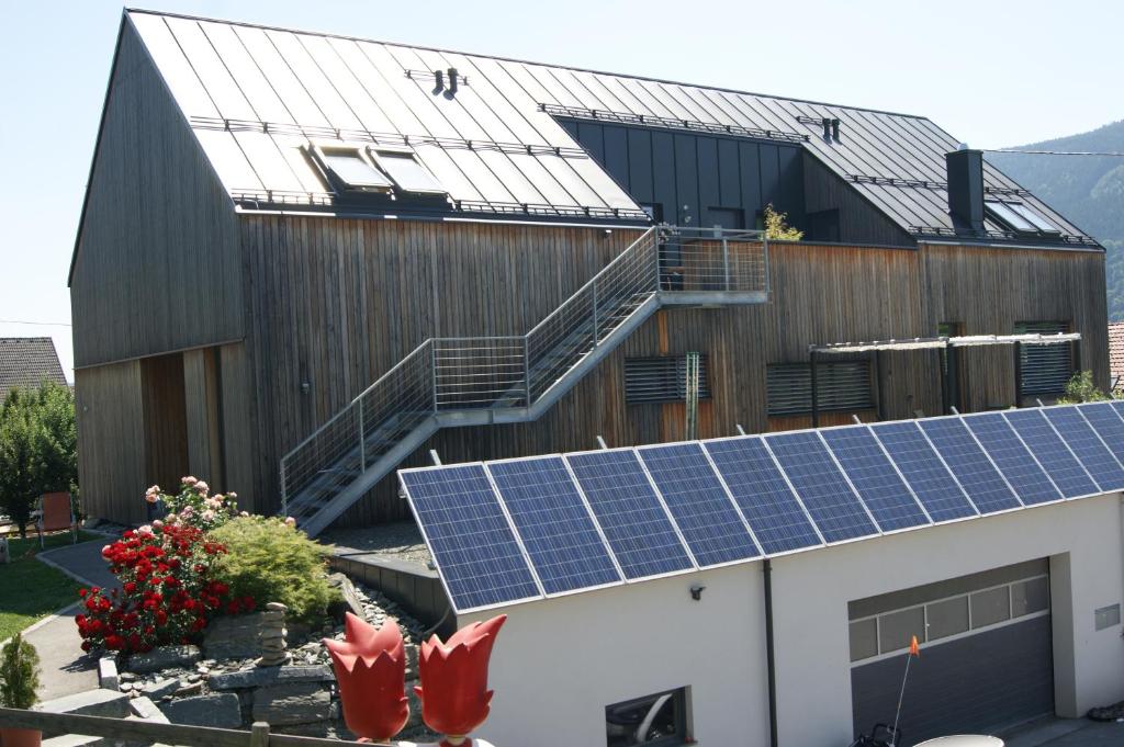 ein Haus mit Sonnenkollektoren auf dem Dach in der Unterkunft Ferienwohnung Frieser in Steindorf am Ossiacher See