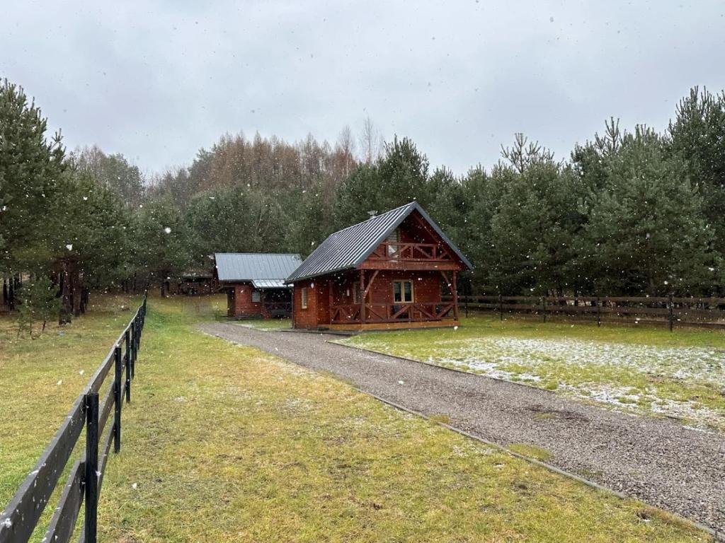 AdamÃ³wDomki całoroczne u Greściaków的围栏旁的木谷仓