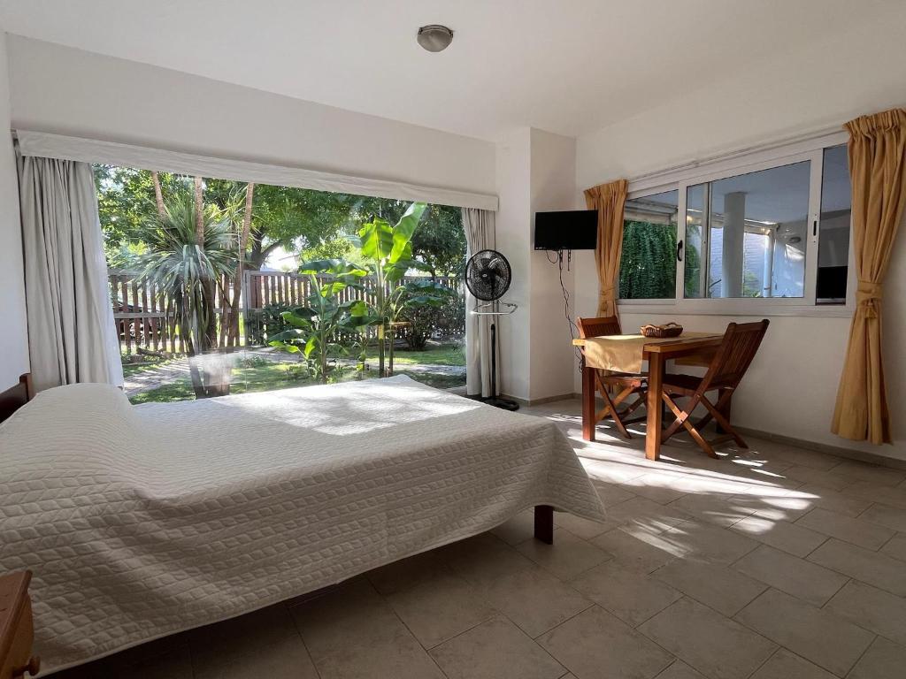 Un dormitorio con una cama y un escritorio y una ventana. en Mi Universo, en Villa Cura Brochero