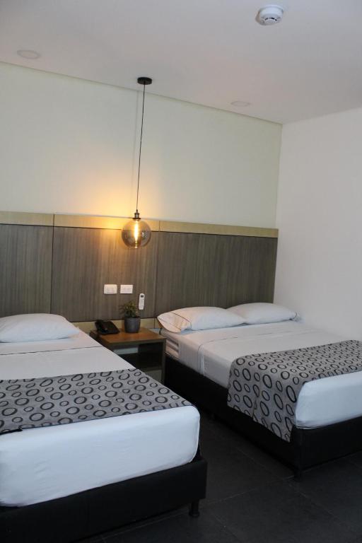 Postel nebo postele na pokoji v ubytování Hotel Merlott Lleras