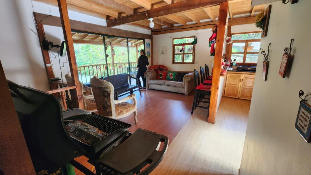 Una persona está parada en una sala de estar. en Finca Acogedora con Área de BBQ, Parking Privado y Hamacas, en Guarne