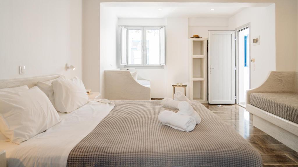 um quarto branco com uma cama grande com travesseiros brancos em Pension George em Karterados