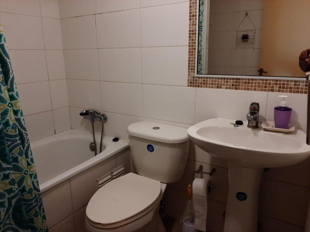ein Badezimmer mit Toilette, Waschbecken und Badewanne in der Unterkunft Departamento portal del mar in La Serena