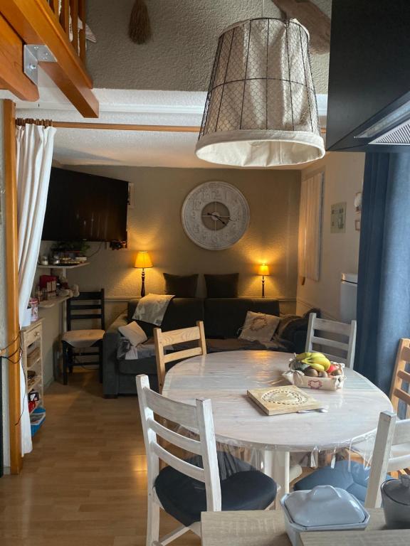 une cuisine et un salon avec une table et un canapé dans l'établissement Les blanches aiguilles, aux Carroz d'Arâches