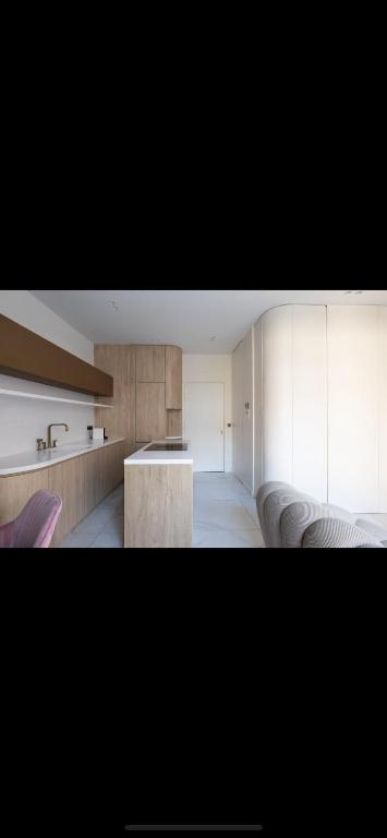 une cuisine avec des armoires blanches et une table dans une pièce dans l'établissement Villamelina, à Puteaux