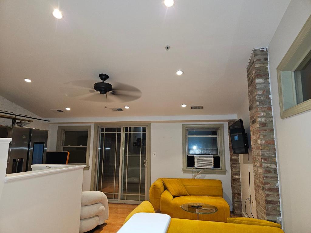 a living room with a yellow couch and a ceiling fan at Dc Play House Bed and Breakfast in Washington