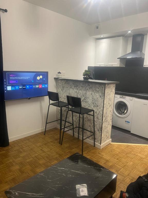 une cuisine avec deux chaises et un comptoir avec un lave-linge dans l'établissement Flixhouse, à Rouen