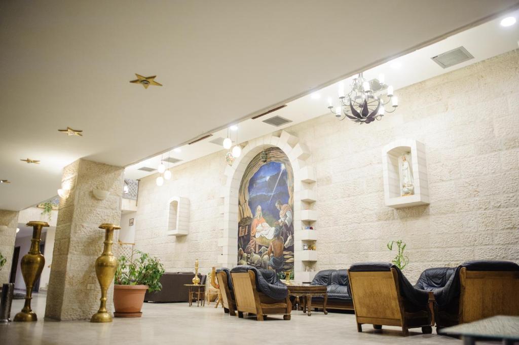 una hall con sedie e un dipinto sul muro di Bethlehem Hotel a Bethlehem