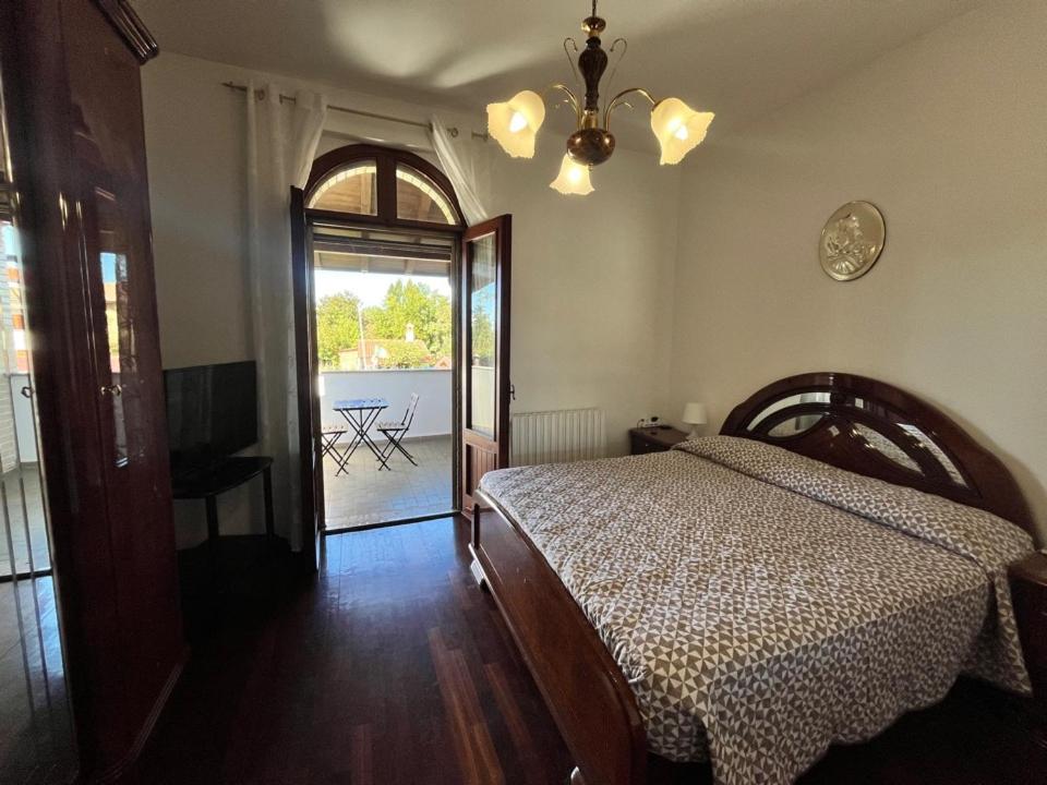 Gaggianoにあるvilla Geranio confortevole villa nei pressi di Milanoのベッドとパティオの眺めのあるベッドルーム