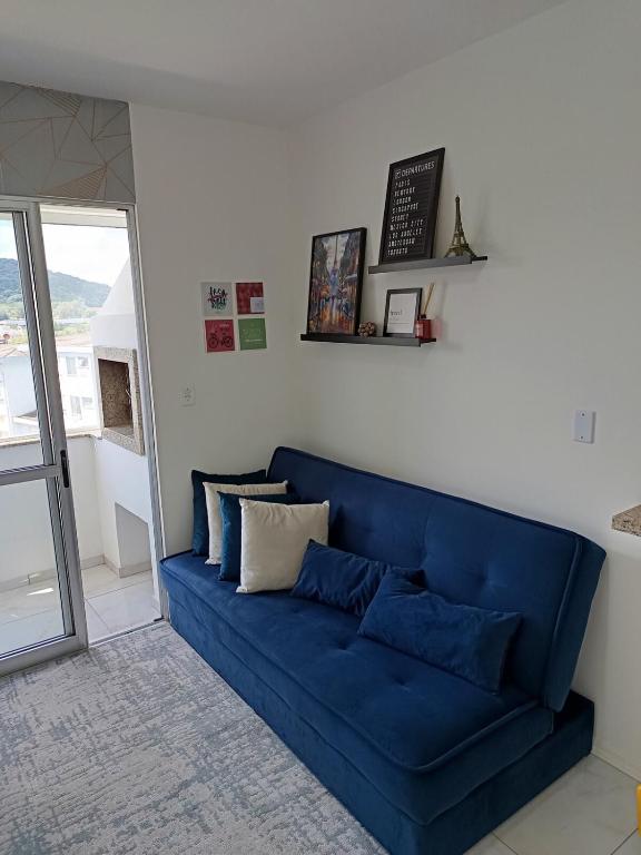 a blue couch in a living room with a window at Apto Paris in Santa Maria