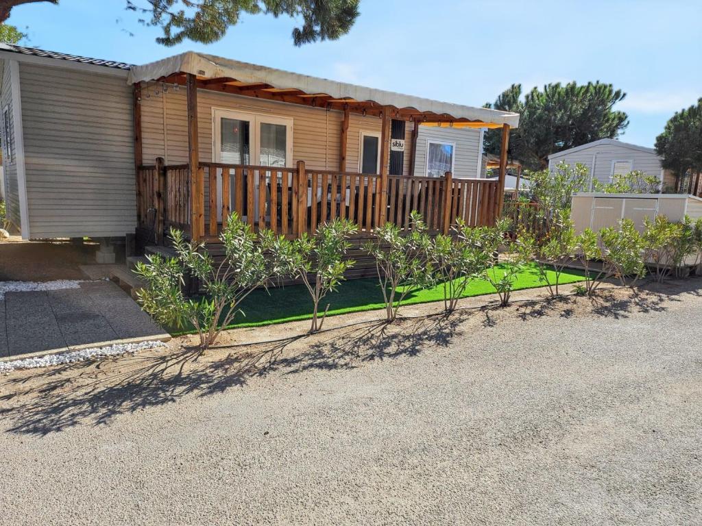 une maison avec un jardin devant dans l'établissement Bungalow cosy à Canet-en-Roussillon avec piscine partagée, à Canet