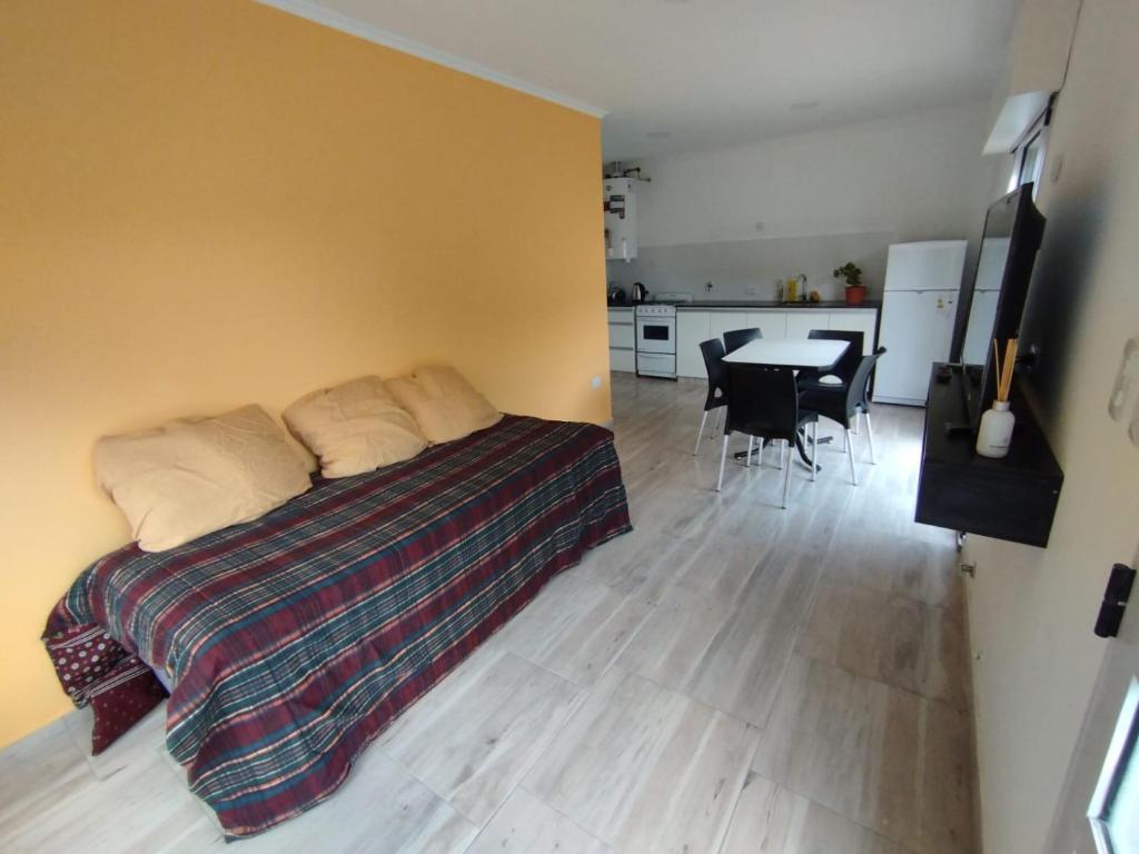 a bedroom with a bed and a table with chairs at Cabañas del monte in Monte Hermoso