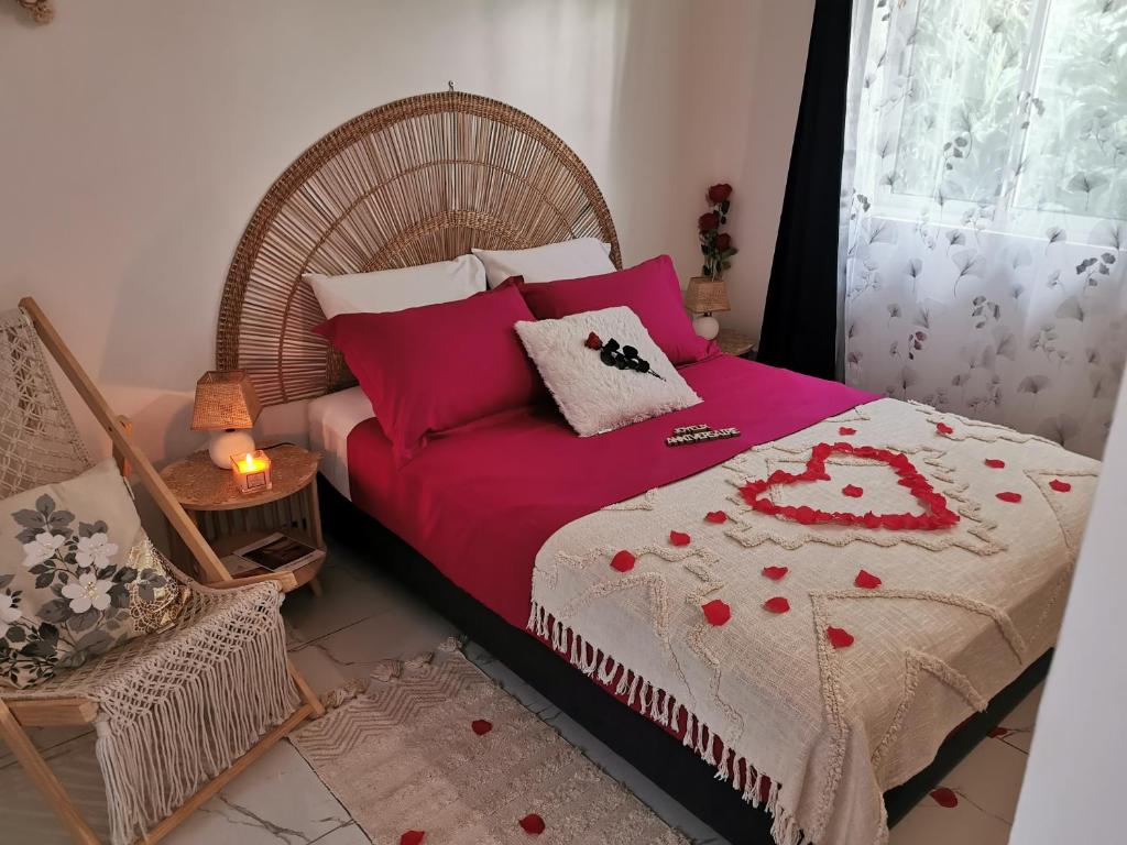 圣弗朗索瓦Au Paradis des oiseaux的一间卧室，有一张床，上面铺着红毯子，还有一扇窗户