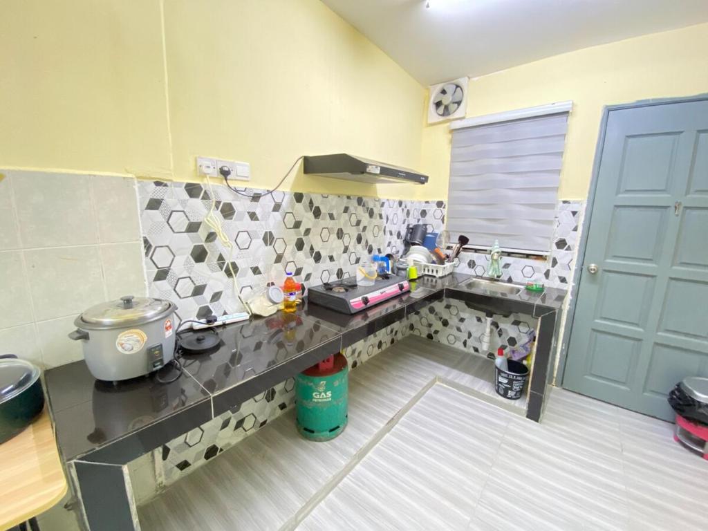 a kitchen with a counter and a table in a room at Homestay Tanjung Malim DMalim in TanjongMalim