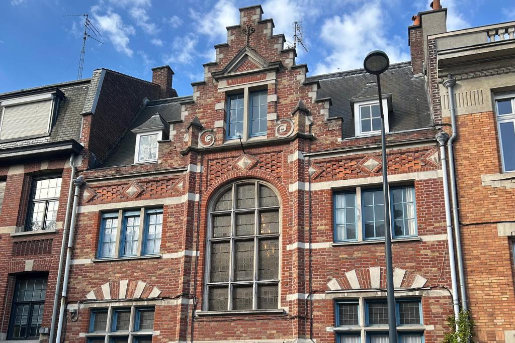 an old red brick building with a tower at Equilibrium Family House by E in Roubaix