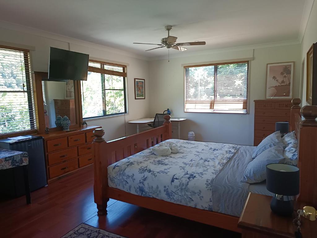 a bedroom with a bed and a kitchen with windows at Quand0ng Valley Inn The Waterfall Room in Minynon