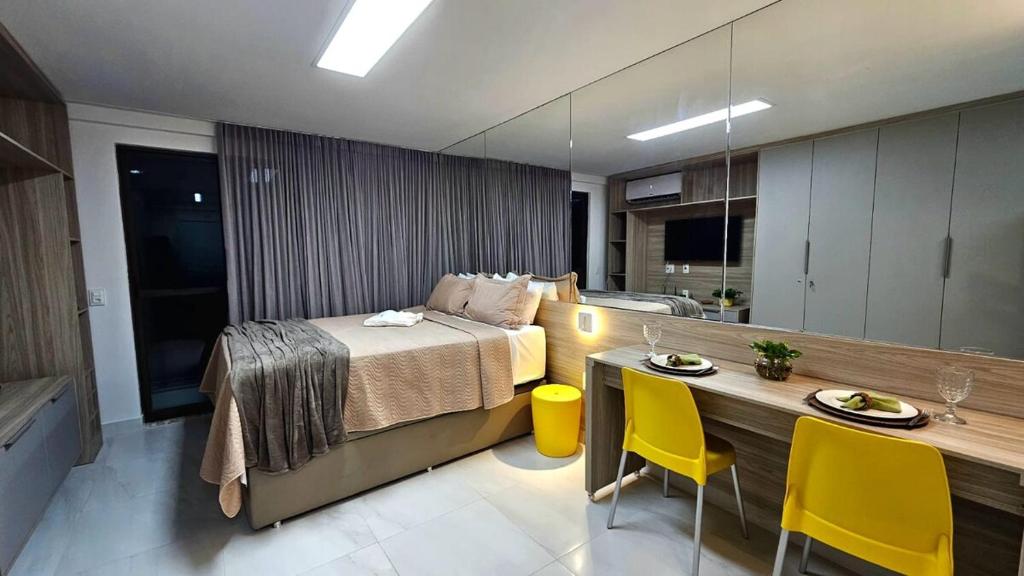 sypialnia z łóżkiem i stołem z żółtymi krzesłami w obiekcie Luxury Flat dos Sonhos - Edificio Compact Tambau w mieście João Pessoa