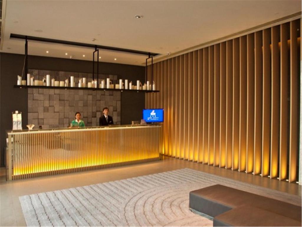 a lobby with a bar with two people at a counter at Jinjiang Inn Fuzhou Cangshan Olympic Centre in Fuzhou