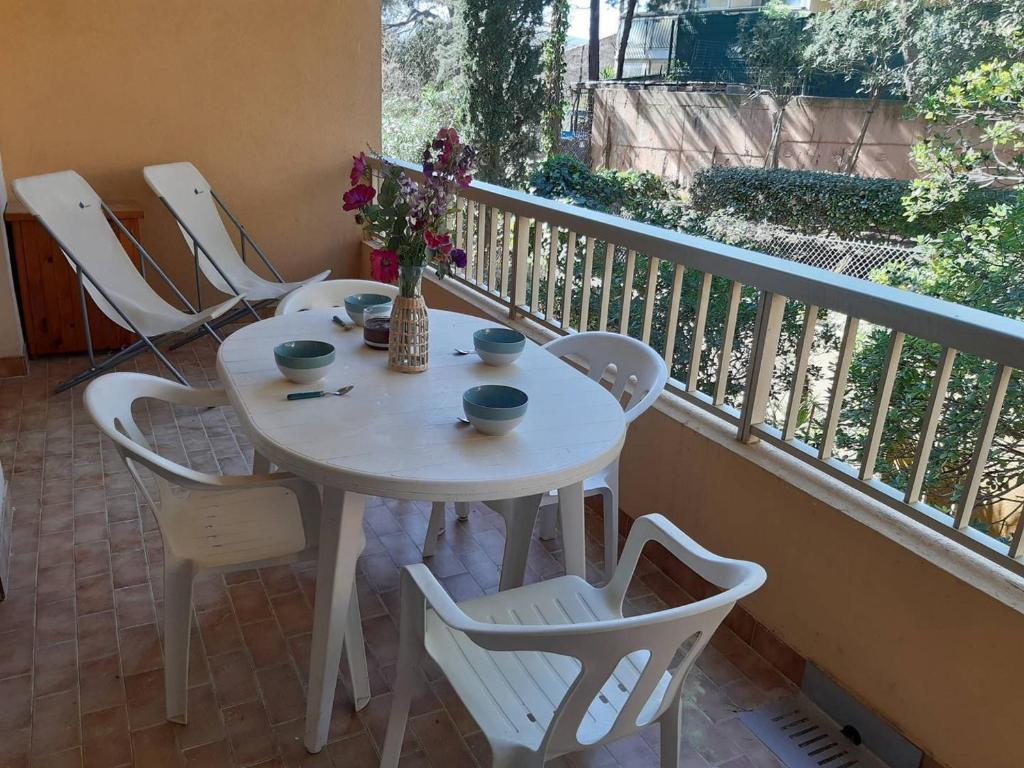 une table blanche et des chaises sur un balcon dans l'établissement Appartement 2P, 4 pers, terrasse, parking, plage à 250m - Bormes-les-Mimosas - FR-1-251-853, à Bormes-les-Mimosas