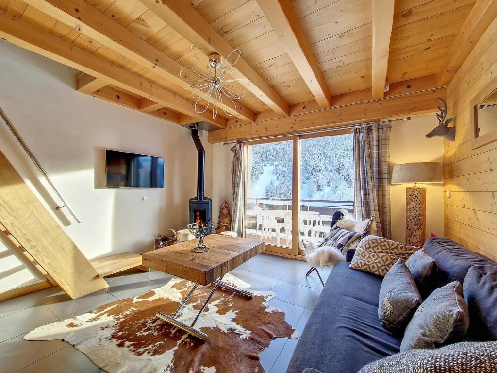 - un salon avec un canapé bleu et un plafond en bois dans l'établissement Duplex cosy 6 pers, 2 ch, garage, La Clusaz - FR-1-818-20, à La Clusaz