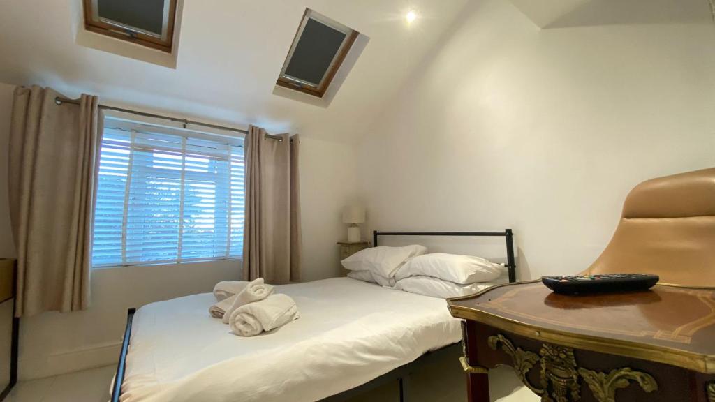 ein Schlafzimmer mit zwei Betten und einem Schreibtisch und einem Fenster in der Unterkunft 1 Bedroom, Near Alexandra Palace - London - Kings Cross - New Southgate Suite 1 in New Southgate