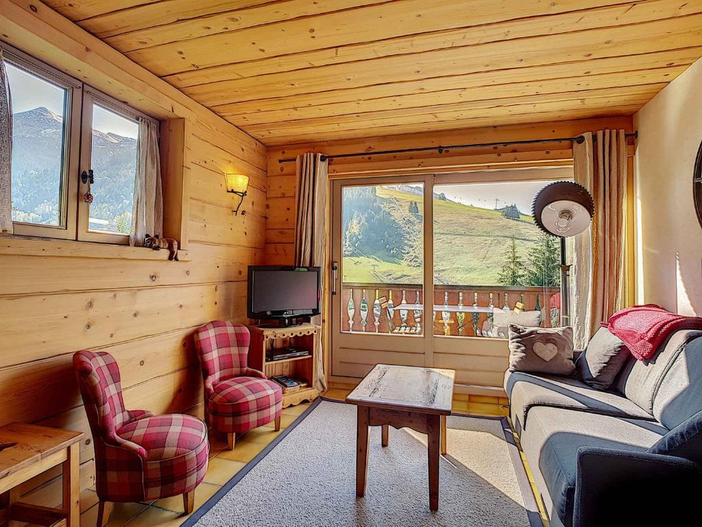 un salon avec un canapé, des chaises et une télévision dans l'établissement La Clusaz - Appartement familial pour 6 pers avec 2 chambres et balcon - FR-1-818-16, à La Clusaz