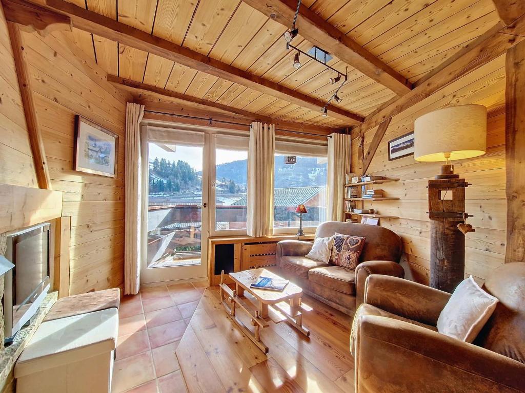 - un salon avec un canapé et une télévision dans une cabine dans l'établissement Appartement 6 pers, 2 chambres, La Clusaz, WIFI, parking - FR-1-818-70, à La Clusaz
