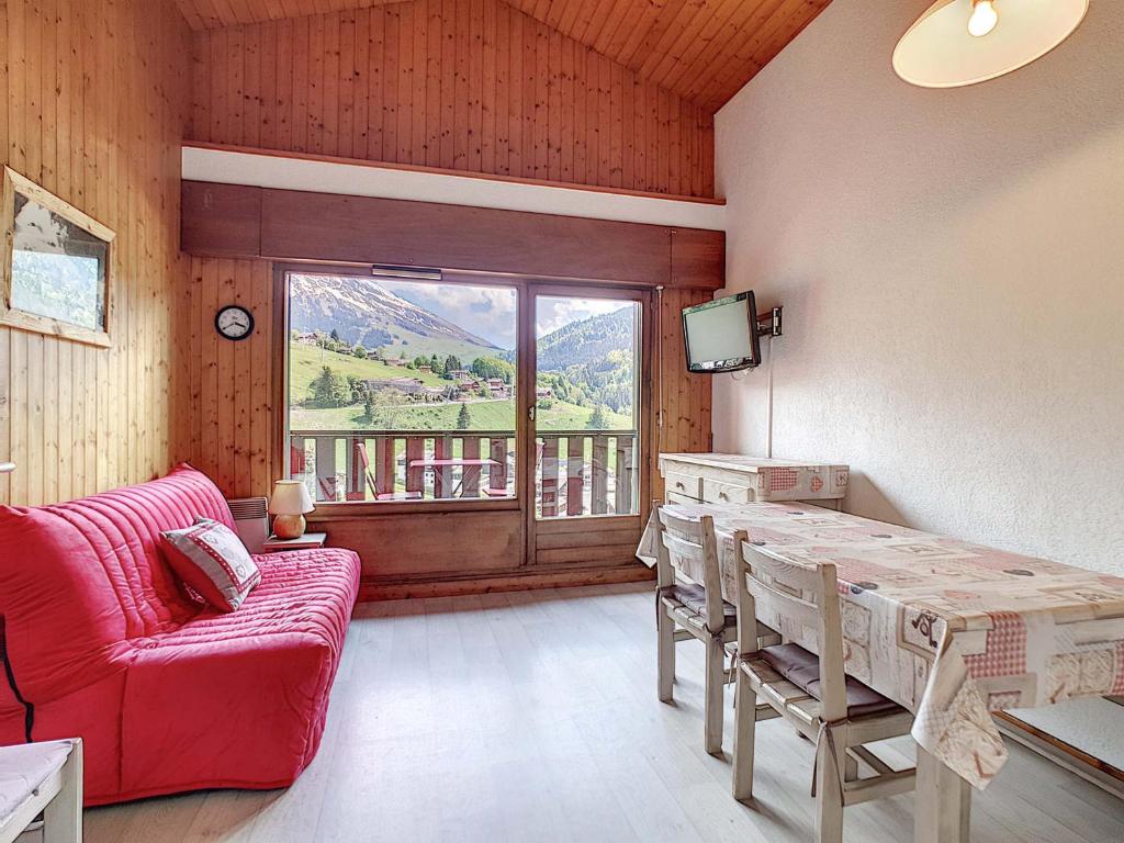 un salon avec un canapé rouge et une table dans l'établissement Charmant appart 4 pers, balcon sud, garage, WiFi, La Clusaz - FR-1-818-67, à La Clusaz