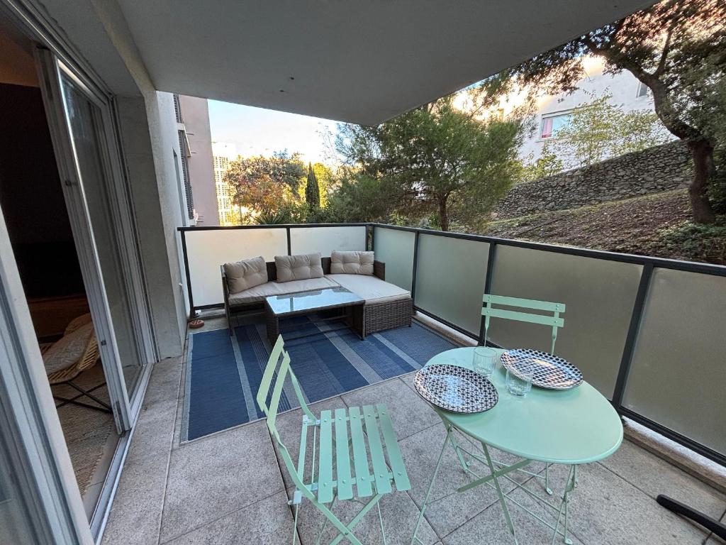 d'un balcon avec une table, des chaises et un canapé. dans l'établissement Confort moderne à Sète : 2 pièces, parking, WIFI - FR-1-338-594, à Sète