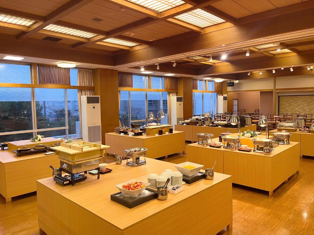 una grande stanza con tavoli con sopra del cibo di Itoen Hotel a Ito