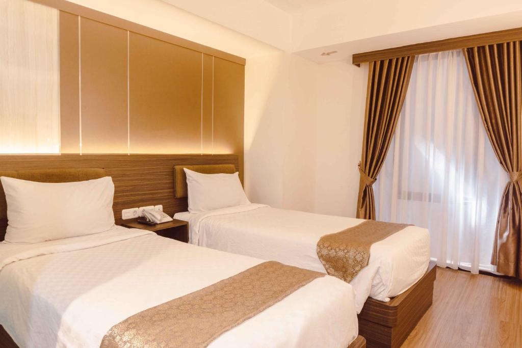 Postel nebo postele na pokoji v ubytování Fahira Hotel Syariah Bukittinggi