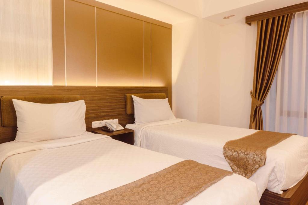 Postel nebo postele na pokoji v ubytování Fahira Hotel Syariah Bukittinggi