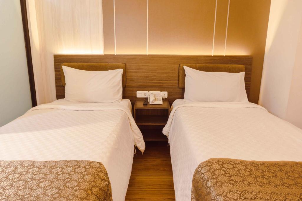 Postel nebo postele na pokoji v ubytování Fahira Hotel Syariah Bukittinggi