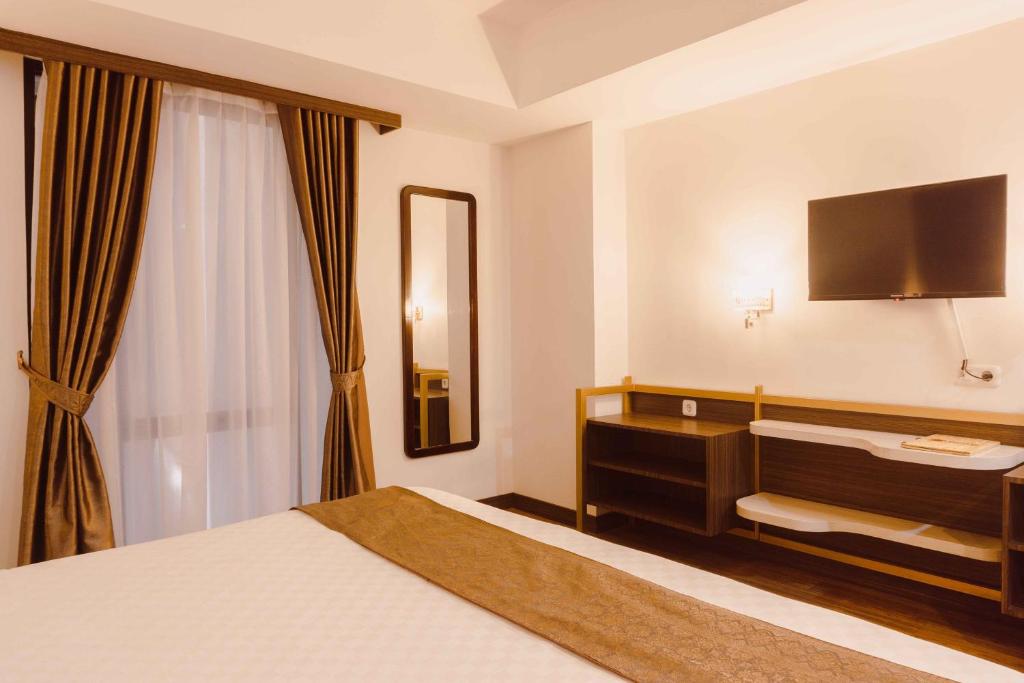 Postel nebo postele na pokoji v ubytování Fahira Hotel Syariah Bukittinggi