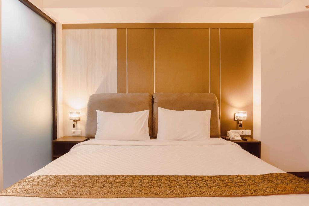 Postel nebo postele na pokoji v ubytování Fahira Hotel Syariah Bukittinggi