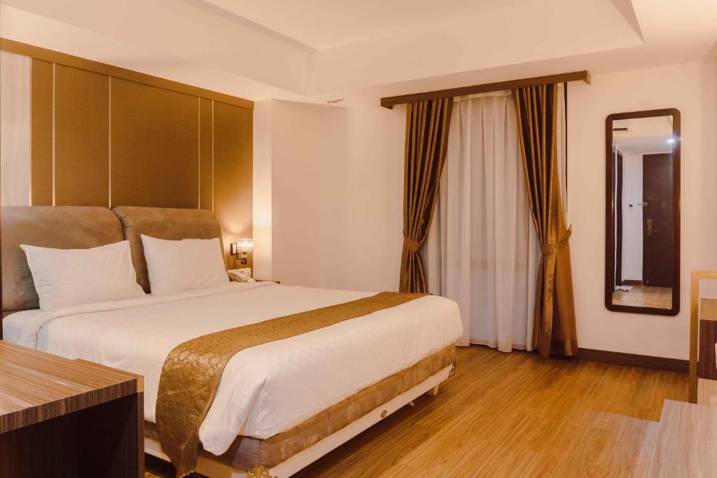 Postel nebo postele na pokoji v ubytování Fahira Hotel Syariah Bukittinggi