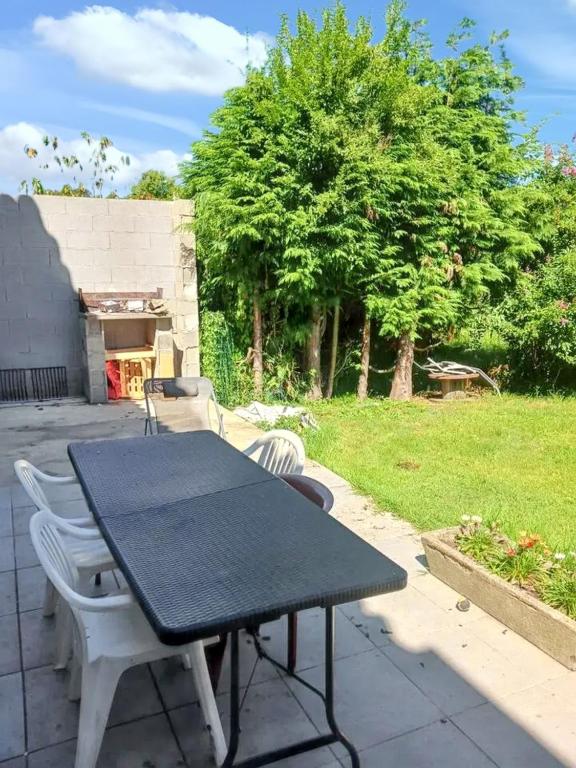 une table noire et des chaises sur une terrasse dans l'établissement Maison charmante à Prat-Bonrepaux avec vue sur la montagne, à Prat-et-Bonrepaux