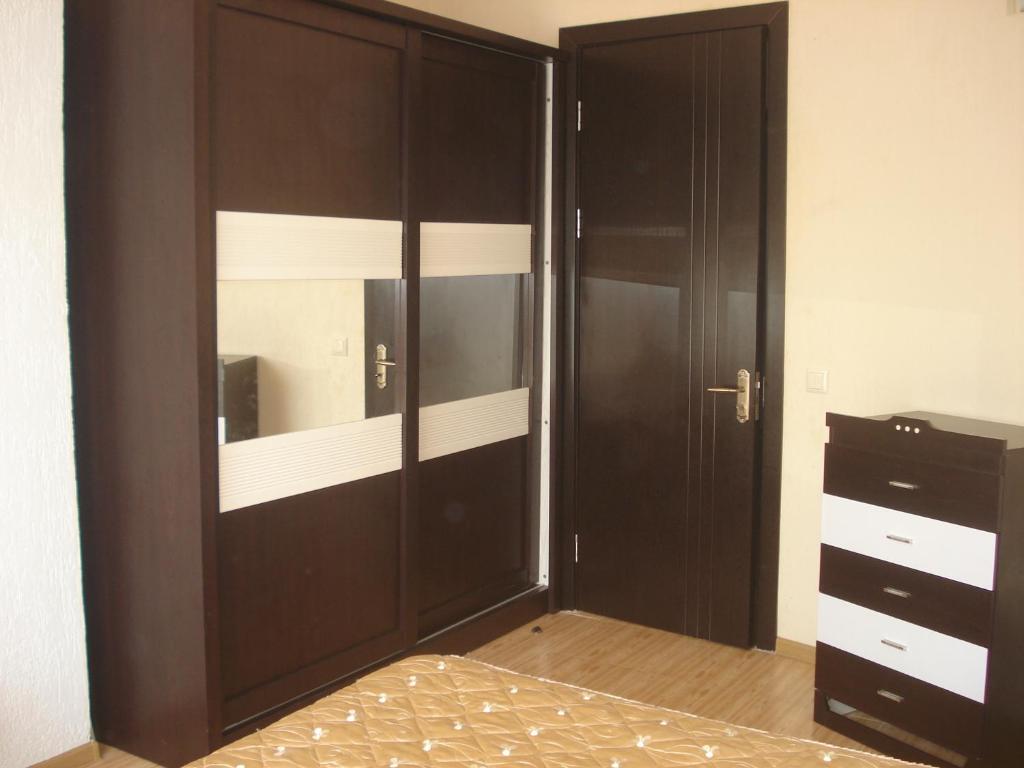 um quarto com um grande guarda-roupa de madeira e uma cama em Apartment Zhemchuzhina Ureki em Ureki