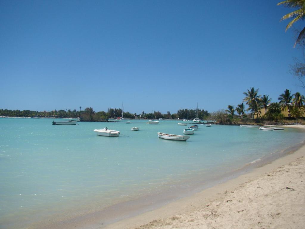 a group of boats in the water on a beach at Althea's nice, comfy 4 BR townhouse with pool in Grand Bay- AH 1 in Grand Baie