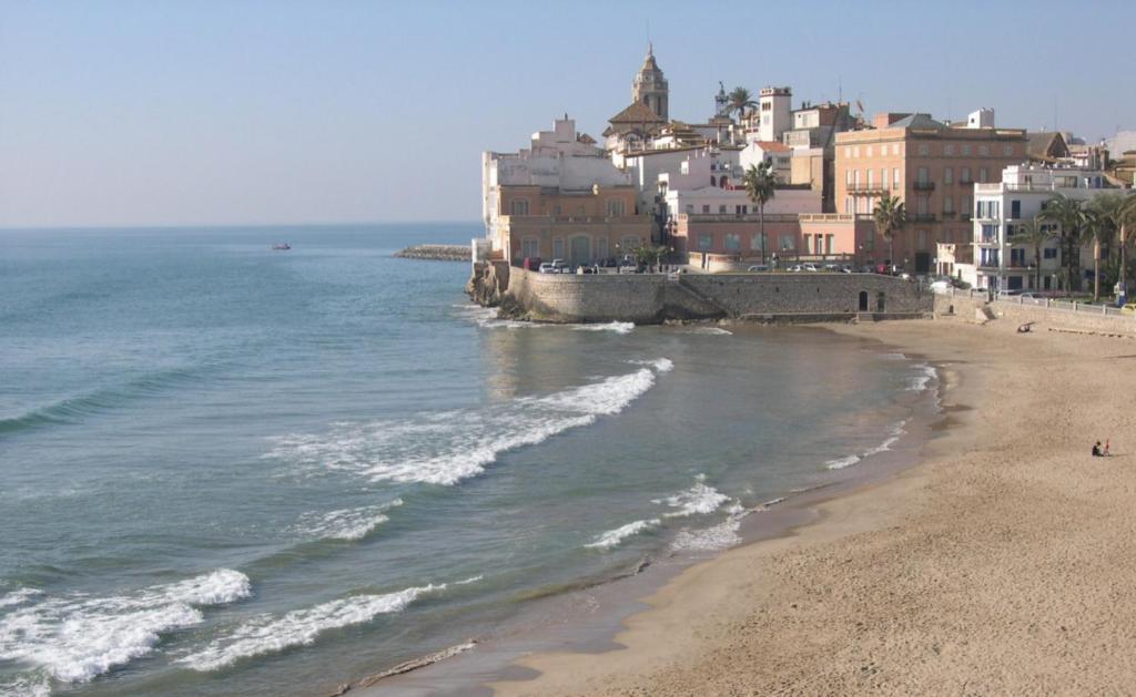 a view of a beach with buildings and the ocean at Rustic good in Sitges