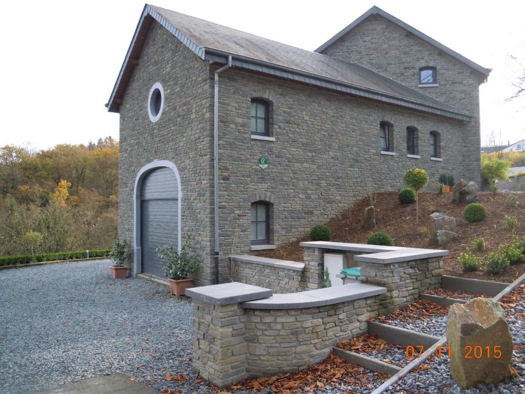 a brick house with a bench in front of it at Gîte Le Gros Chêne in Bouillon